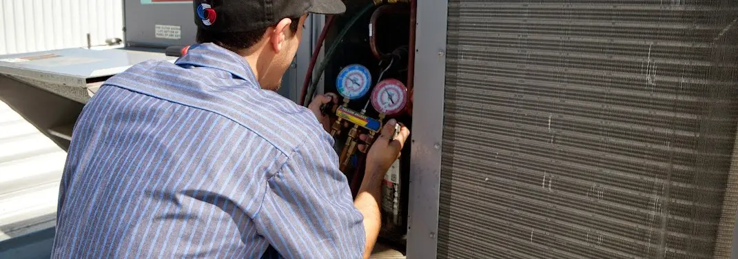 HVAC technician servicing a condenser unit in Alpine
