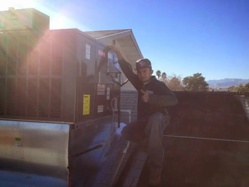 HVAC technician performing HVAC Inspection on a rooftop unit in Alpine